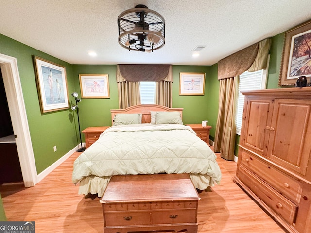 bedroom featuring light hardwood / wood-style flooring and a textured ceiling