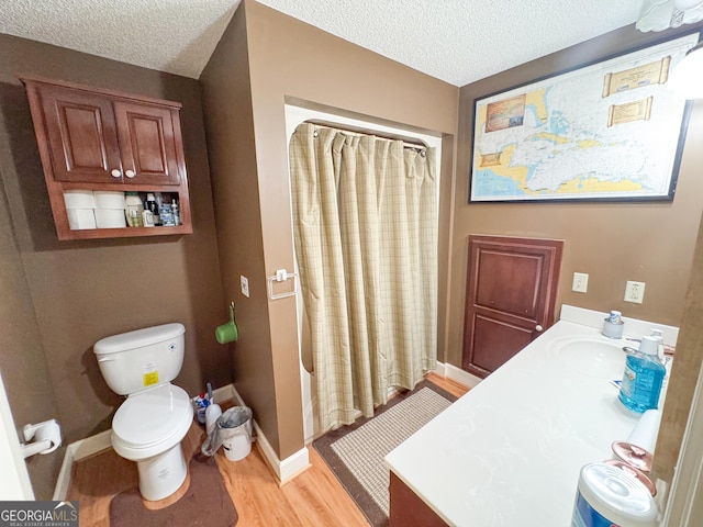 bathroom with hardwood / wood-style flooring, vanity, curtained shower, and a textured ceiling