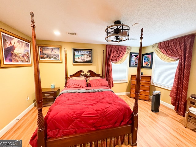 bedroom with hardwood / wood-style floors and a textured ceiling