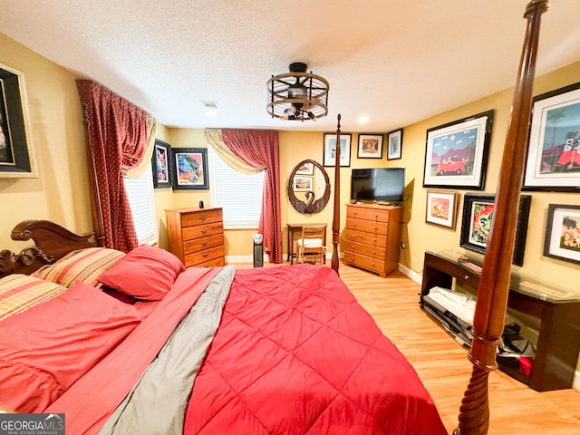 bedroom featuring hardwood / wood-style floors and a textured ceiling