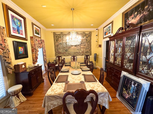 dining area featuring hardwood / wood-style floors, crown molding, and a chandelier