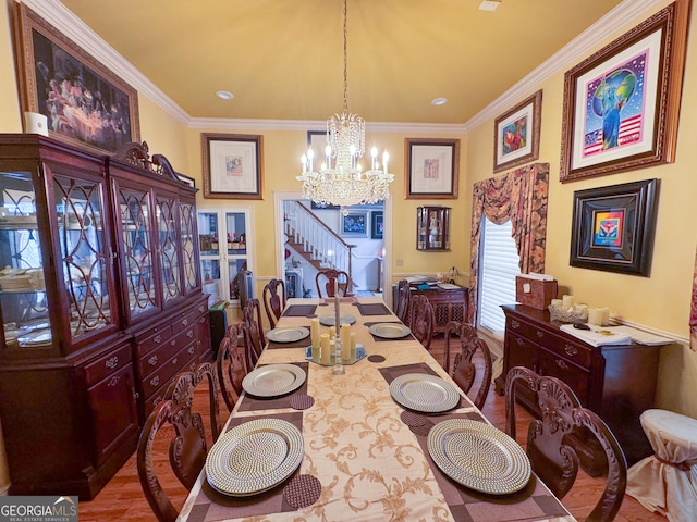 dining area featuring crown molding, wood-type flooring, and an inviting chandelier