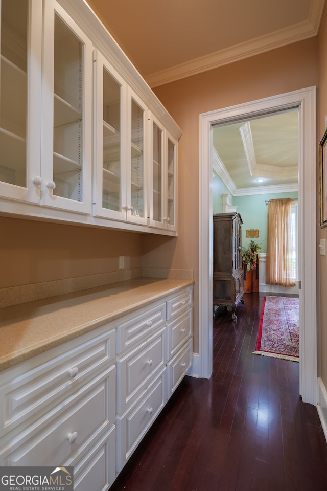 interior space featuring dark hardwood / wood-style flooring, a raised ceiling, and crown molding