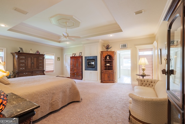 carpeted bedroom featuring ensuite bath, ceiling fan, a raised ceiling, and ornamental molding