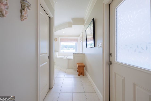 hallway with ornamental molding and light tile flooring