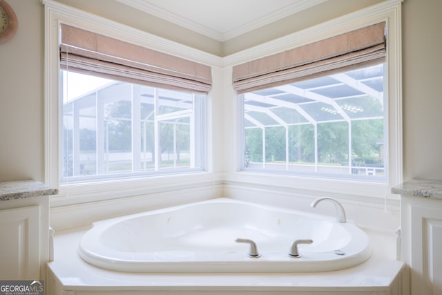 bathroom with a healthy amount of sunlight, ornamental molding, vanity, and a bathtub