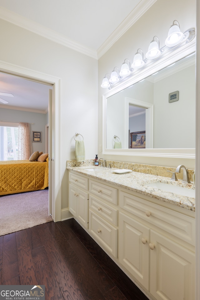 bathroom with crown molding, dual bowl vanity, and hardwood / wood-style floors