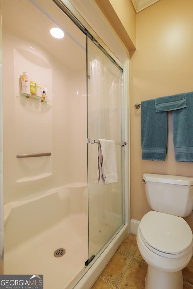 bathroom with walk in shower, tile flooring, and toilet