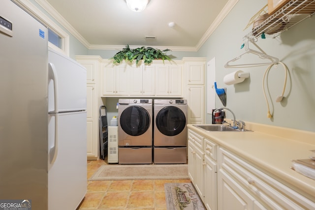 clothes washing area featuring cabinets, independent washer and dryer, crown molding, sink, and light tile floors