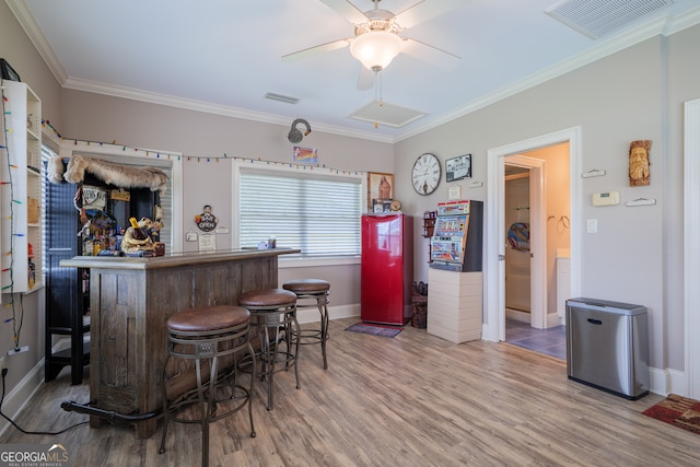 bar featuring crown molding, wood-type flooring, ceiling fan, and fridge