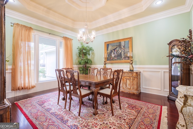 dining space featuring ornamental molding, a chandelier, a raised ceiling, and dark hardwood / wood-style floors