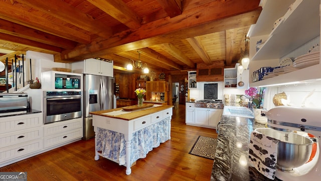 kitchen with beam ceiling, white cabinetry, stainless steel appliances, and wood ceiling