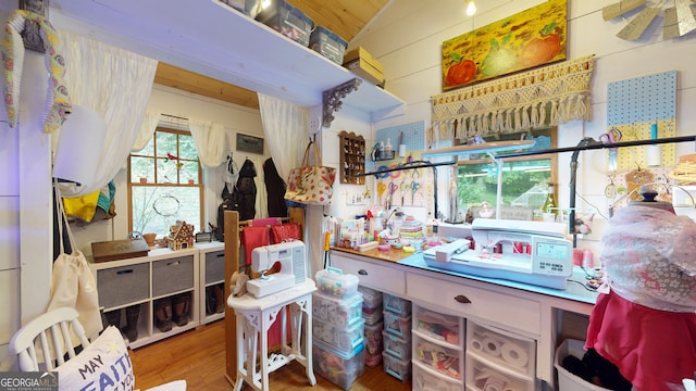 misc room with wood walls, lofted ceiling, and hardwood / wood-style floors