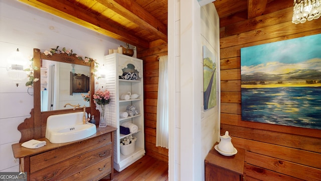 bathroom featuring vanity, beam ceiling, wood ceiling, and wooden walls