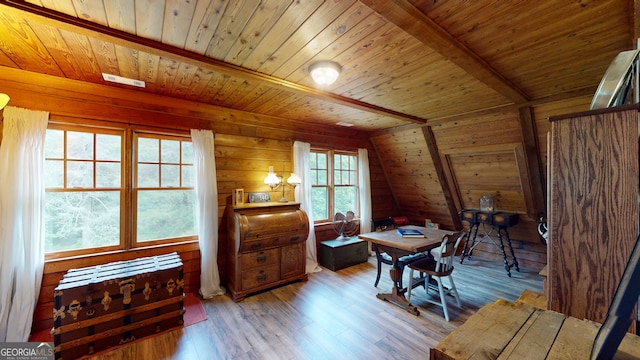 living area with lofted ceiling, light wood-type flooring, wooden walls, and wooden ceiling