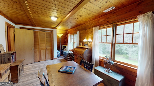 interior space with beamed ceiling, an inviting chandelier, light hardwood / wood-style floors, wood walls, and wooden ceiling