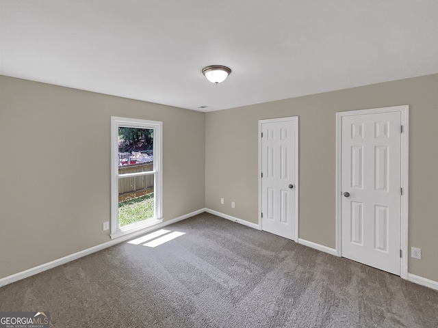 spare room featuring dark carpet