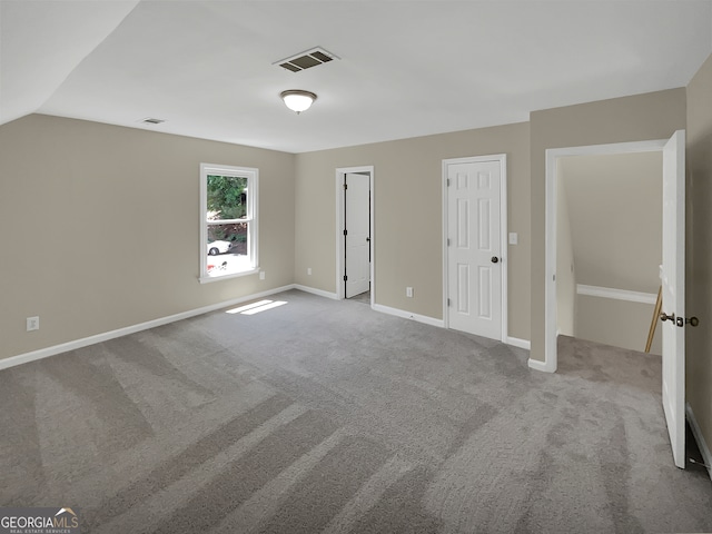 unfurnished bedroom featuring carpet and vaulted ceiling