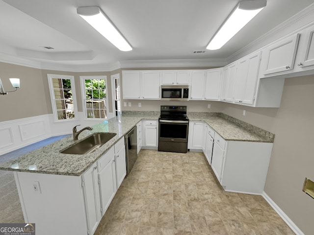 kitchen with crown molding, white cabinetry, light stone countertops, appliances with stainless steel finishes, and sink