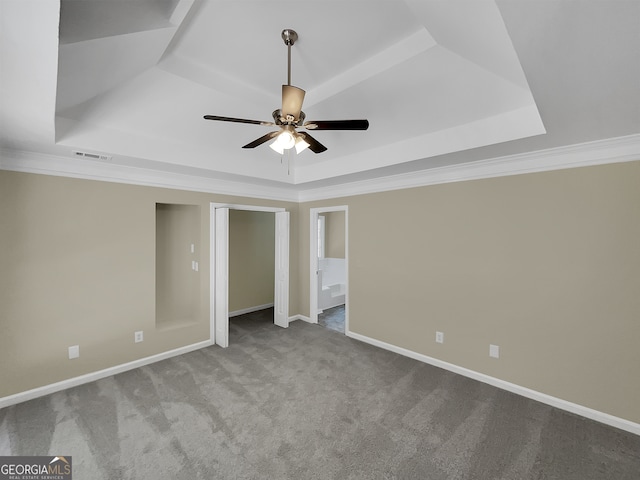 unfurnished bedroom with ceiling fan, a raised ceiling, crown molding, and carpet flooring