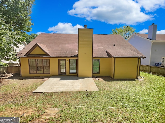 rear view of property featuring a patio and a lawn