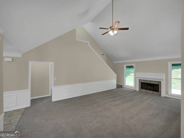 unfurnished living room featuring ceiling fan, plenty of natural light, dark colored carpet, and a fireplace