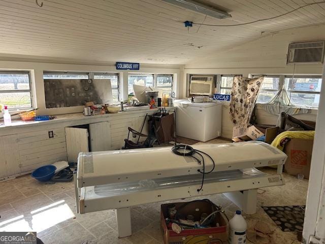 misc room featuring wooden ceiling, a wall mounted AC, and washer / clothes dryer