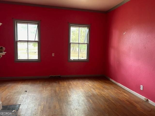 unfurnished room featuring wood-type flooring and crown molding