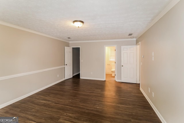 unfurnished bedroom featuring baseboards, dark wood finished floors, ornamental molding, ensuite bathroom, and a textured ceiling