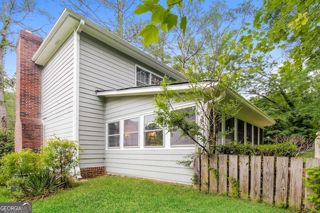 view of property exterior with a yard and fence