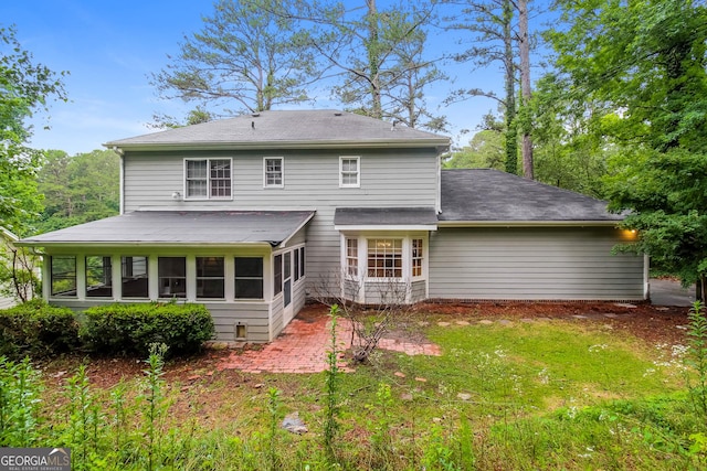 rear view of house with a lawn and a sunroom