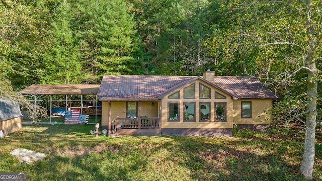 rear view of property with a porch and a lawn