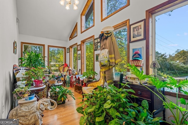 sunroom / solarium with plenty of natural light, vaulted ceiling, and an inviting chandelier