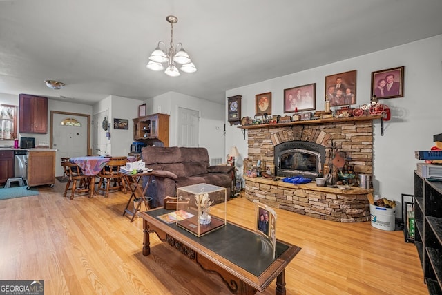 living room featuring light hardwood / wood-style floors, a fireplace, and a chandelier