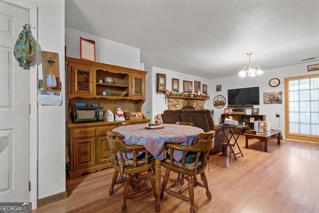 dining room featuring light wood-type flooring and an inviting chandelier