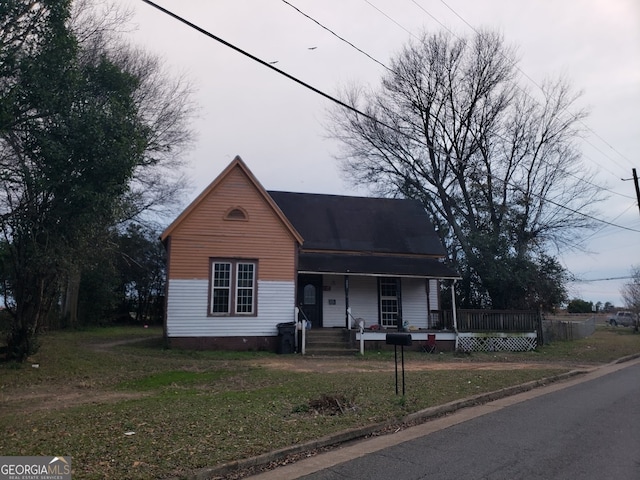 view of front of home with a front yard and covered porch