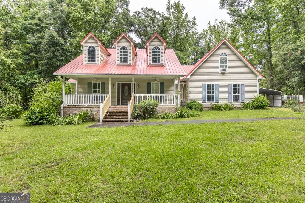 new england style home with a carport, a front lawn, and a porch