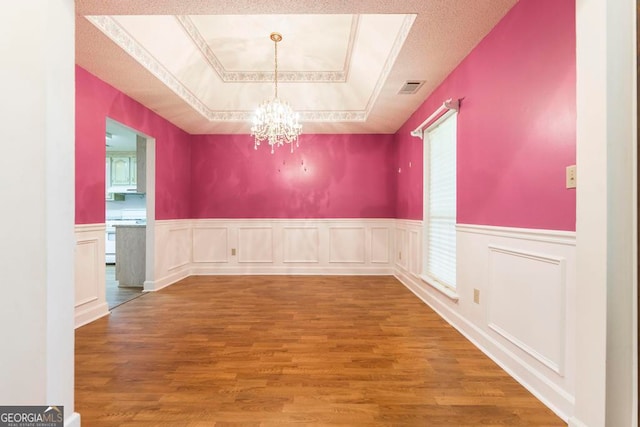 3650 Confederate Dr, Macon, GA 31211 - unfurnished dining area featuring a tray ceiling, hardwood / wood-style flooring, plenty of natural light, and an inviting chandelier