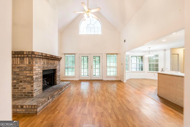 3650 Confederate Dr, Macon, GA 31211 - unfurnished living room with light hardwood / wood-style flooring, a fireplace, ceiling fan with notable chandelier, high vaulted ceiling, and sink