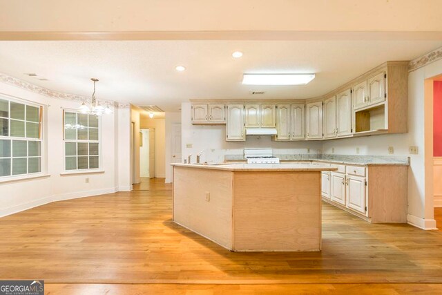 3650 Confederate Dr, Macon, GA 31211 - kitchen with decorative light fixtures, an inviting chandelier, light hardwood / wood-style floors, a kitchen island, and white stove