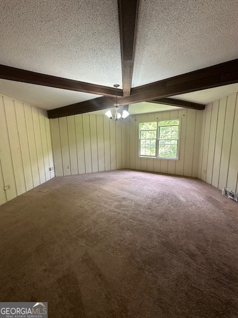 carpeted spare room featuring beam ceiling, an inviting chandelier, and a textured ceiling