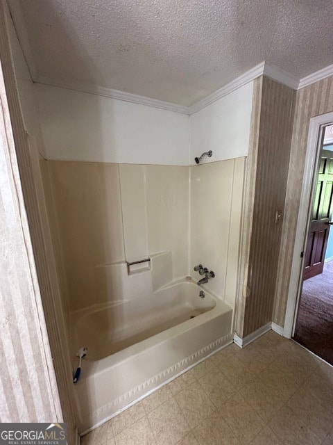 bathroom with tile floors, a textured ceiling, and bathing tub / shower combination