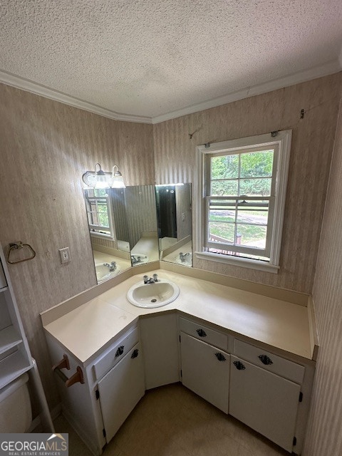 bathroom featuring crown molding, tile flooring, vanity, and a textured ceiling