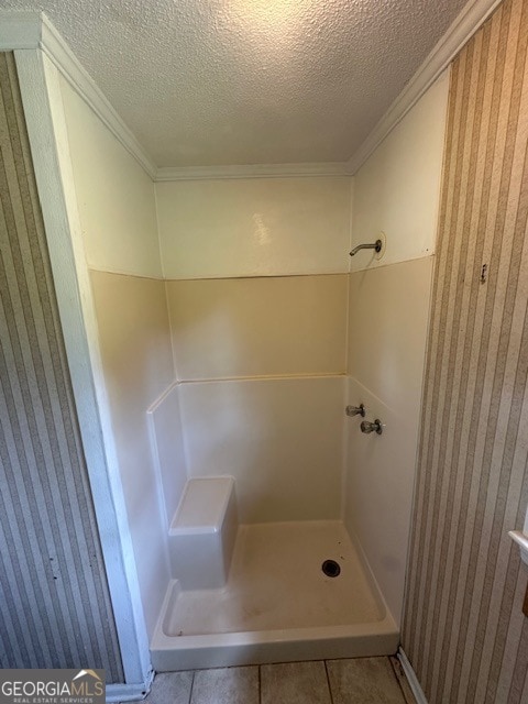 bathroom featuring a shower, tile flooring, and a textured ceiling