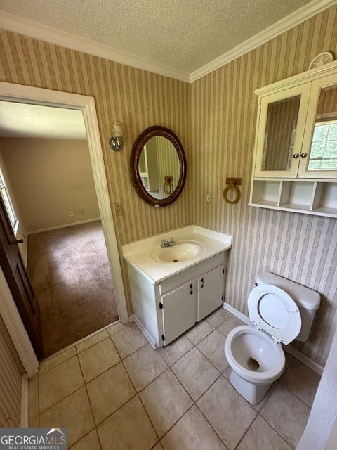 bathroom with tile flooring, a textured ceiling, ornamental molding, and vanity