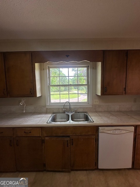 kitchen with sink, dishwasher, and tile countertops