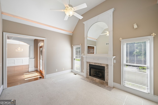 unfurnished living room with carpet, ceiling fan with notable chandelier, and a healthy amount of sunlight