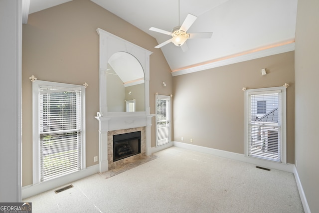 unfurnished living room with high vaulted ceiling, ceiling fan, a fireplace, and carpet flooring