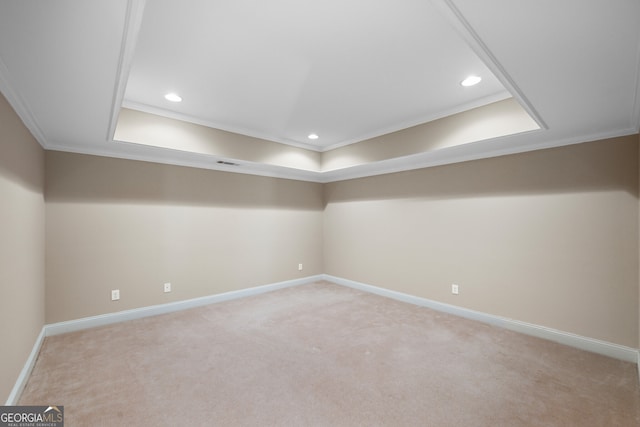 carpeted empty room with a raised ceiling and ornamental molding