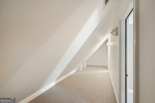 corridor featuring carpet and lofted ceiling